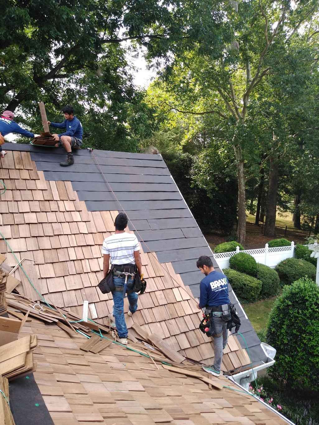 A Vega roofer working the pitch of a steep shingle roof